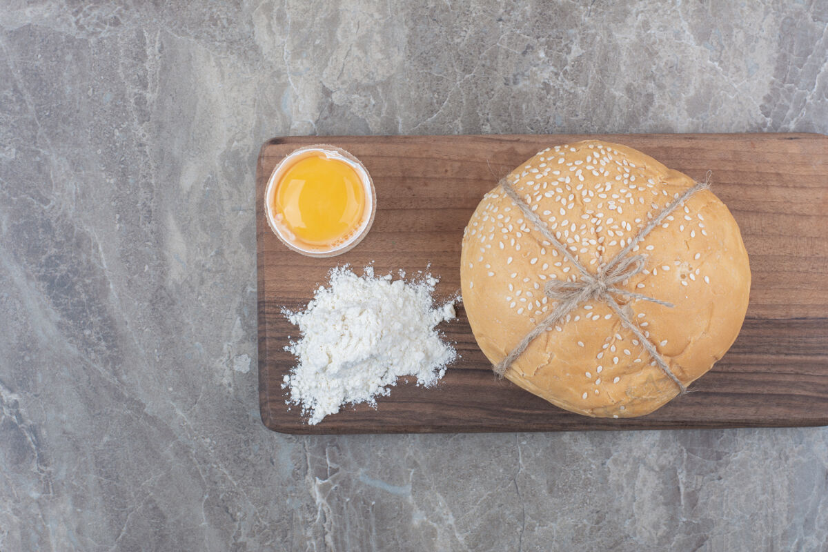 小面包在木板上放一块蛋黄和面粉的白面包面粉好吃的蛋黄