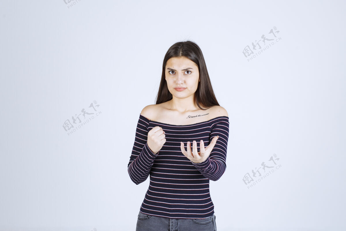 年轻人穿条纹衬衫的女孩伸出拳头人类姿势人体模特