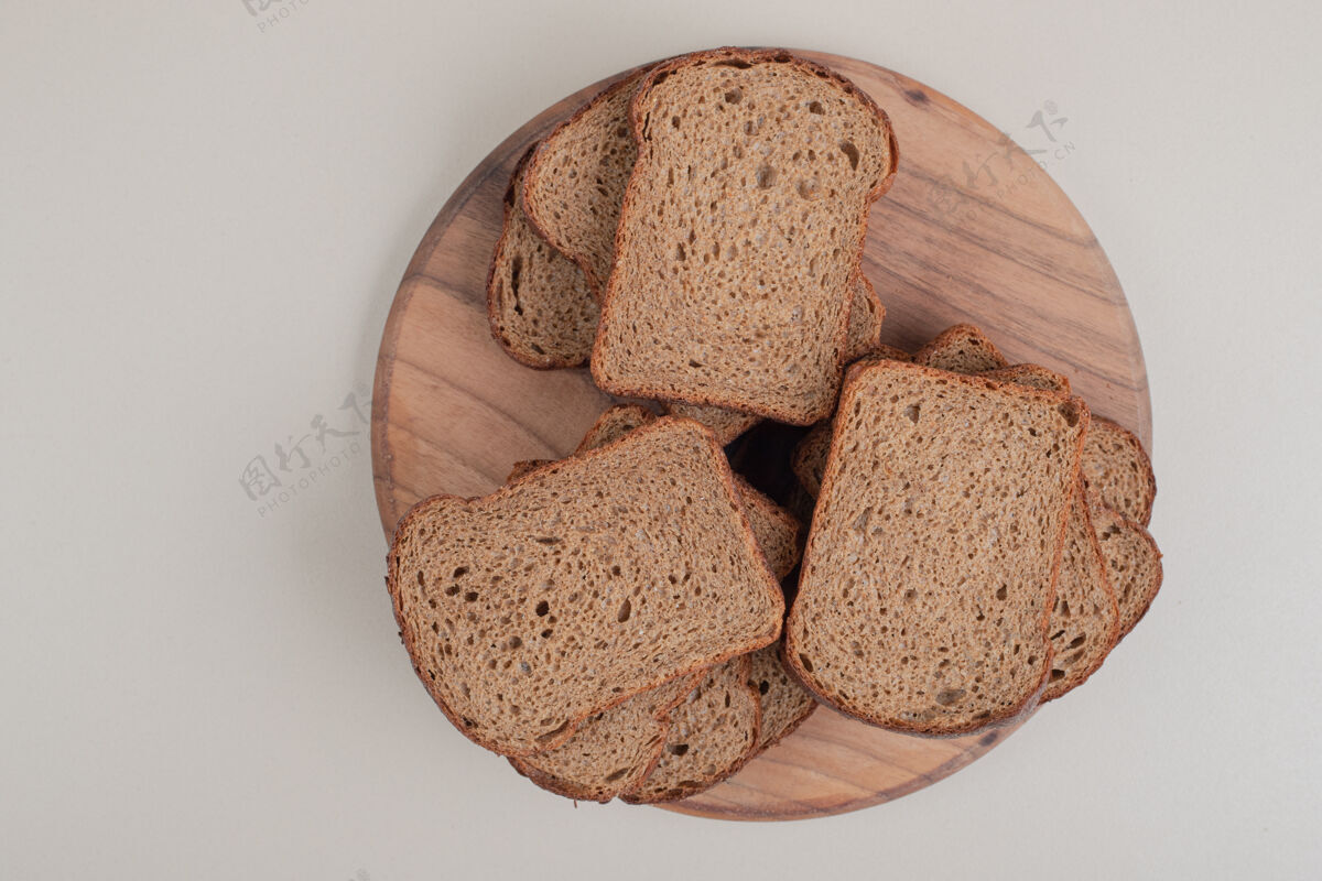 谷类把棕色面包片放在木盘上组餐面包