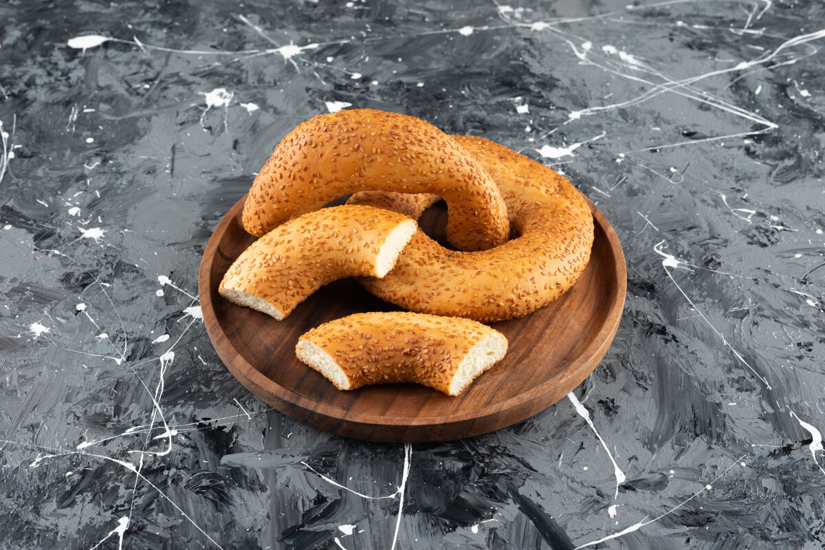 百吉饼土耳其传统的百吉饼西米饼在大理石背景上的木制盘子里面包房土耳其面包健康