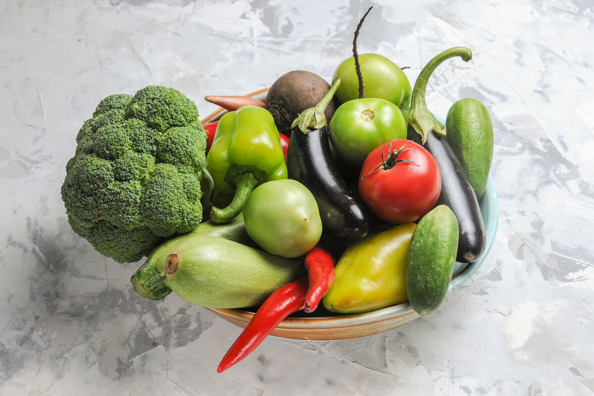 健康前视图新鲜蔬菜组成内盘上白桌沙拉新鲜成熟鳄梨蔬菜苹果