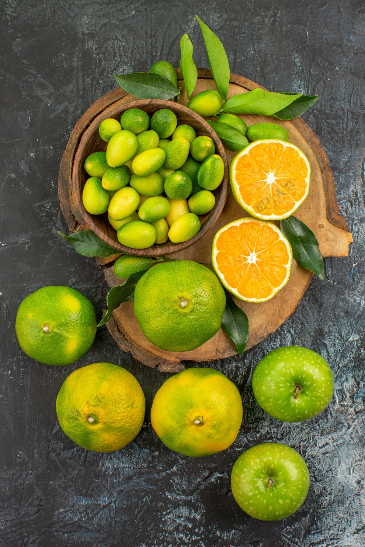 板顶部特写镜头：切菜板上有叶子的柑橘类水果芒果可食用水果切