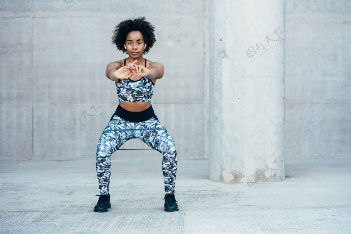 城市一位非洲女运动员在户外锻炼和做蹲腿运动运动健身运动装