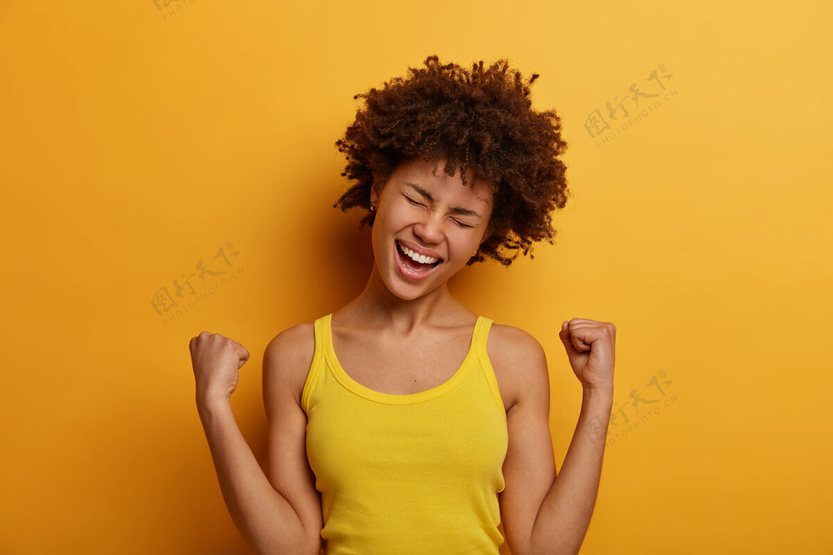 种族胜利的女人为赢得比赛而欢欣鼓舞 积极地歪着头笑出来欣喜若狂模特庆祝