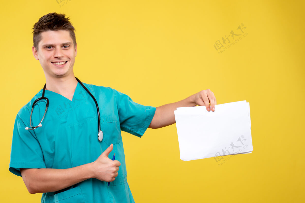 男医生黄色墙壁上的男医生穿着医疗服的正面图人医院医疗