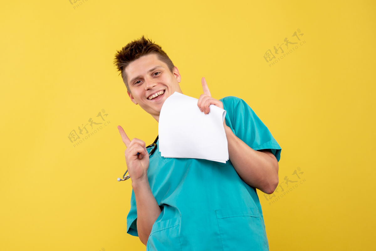 医学黄色墙壁上的男医生穿着医疗服的正面图西装健康情绪