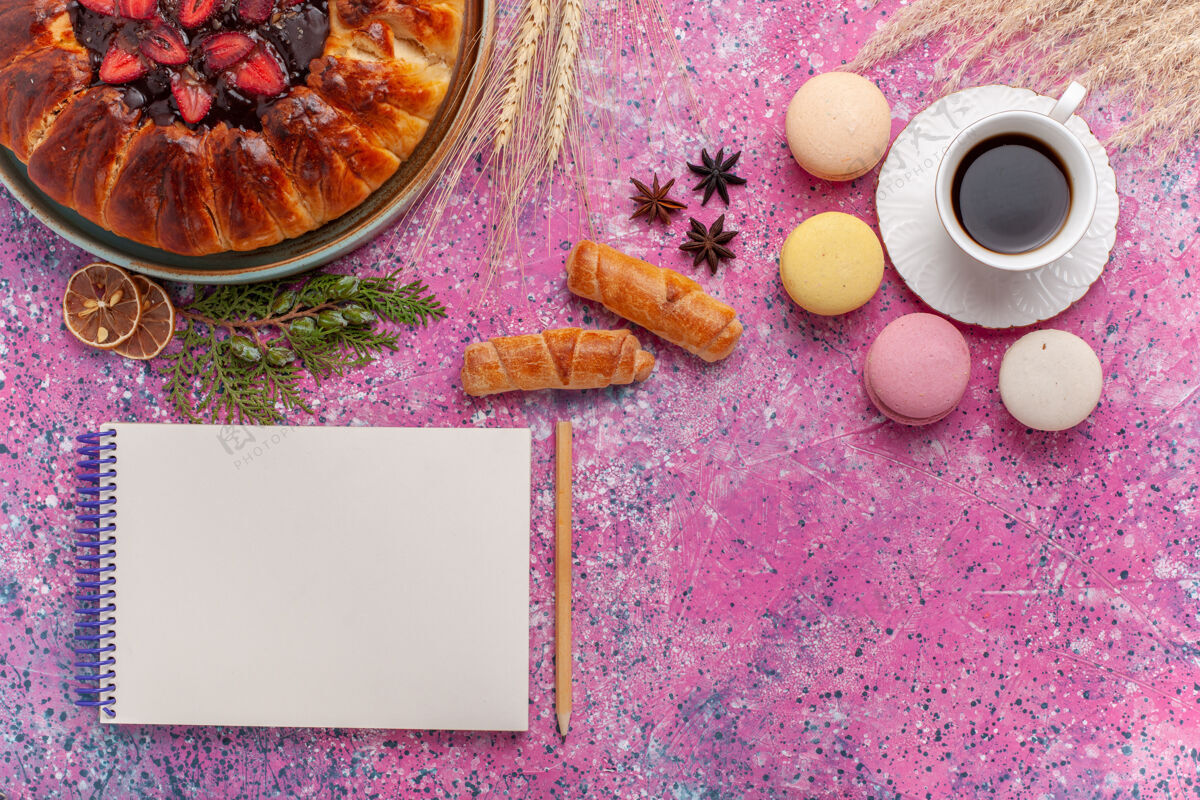 咖啡顶视图美味的草莓派与一杯茶和麦卡龙粉红水果杏仁饼茶
