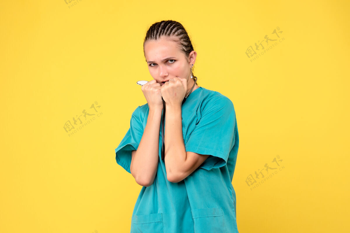 肖像黄色墙壁上穿着带听诊器的医疗服的女医生的正视图西装情绪成人