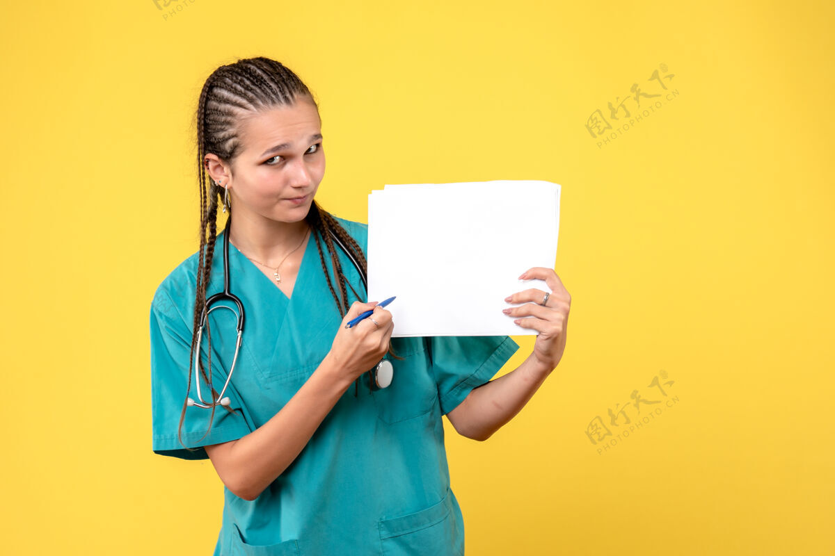 药黄墙上穿着医疗服拿着纸的女医生的正视图人健康医疗器械