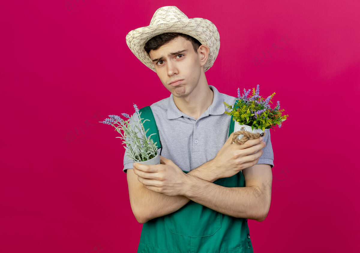 花园悲伤的年轻男园丁戴着园艺帽交叉双臂捧着花盆园艺空间帽子