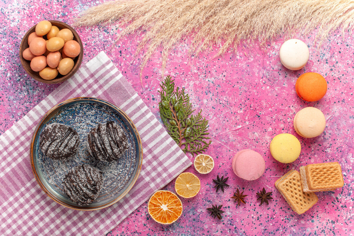 碗俯瞰浅粉色巧克力蛋糕的法国马卡龙饼干香草鸡蛋