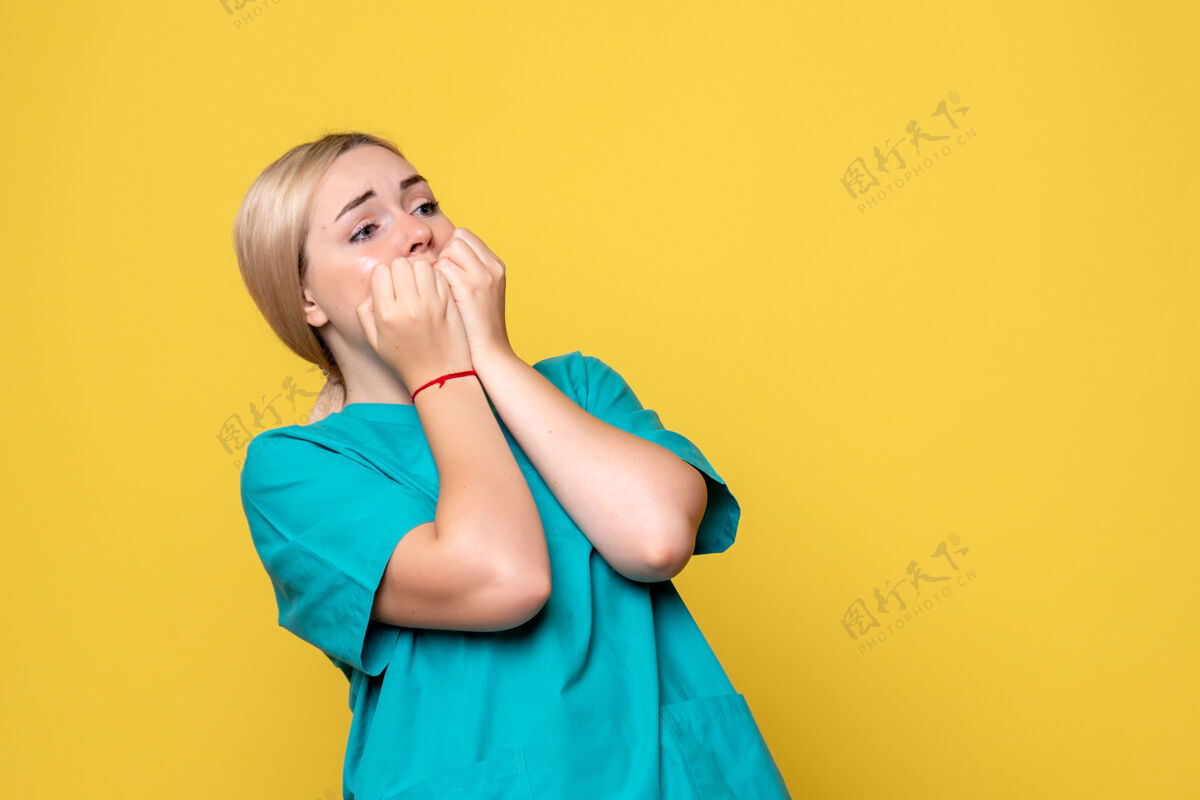 肖像黄墙上年轻女医生穿着医疗衬衫 脸上带着恐惧医学年轻女医生漂亮