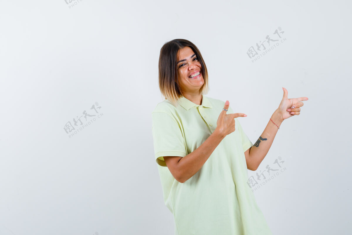 人穿着t恤衫的年轻女孩用食指指着右边 看上去很快乐正视图指头发成人
