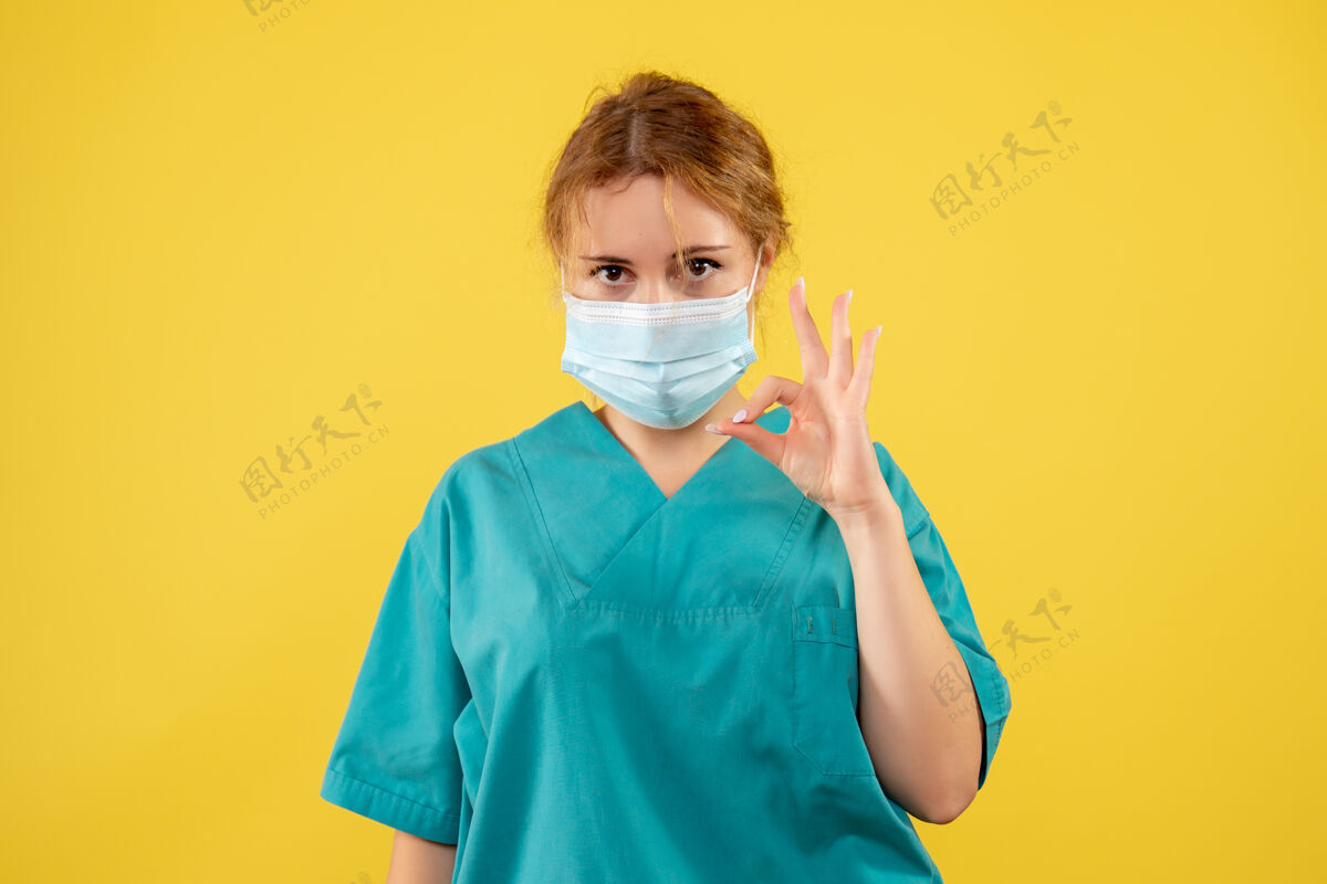 人物黄墙上年轻女医生穿着医疗服 戴着口罩的正面图封面正面防护罩