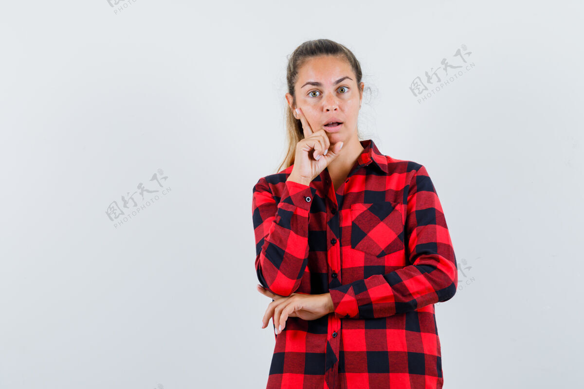 女性穿着格子衬衫的年轻女士站在思考的姿势 看起来很惊讶思考身体衬衫