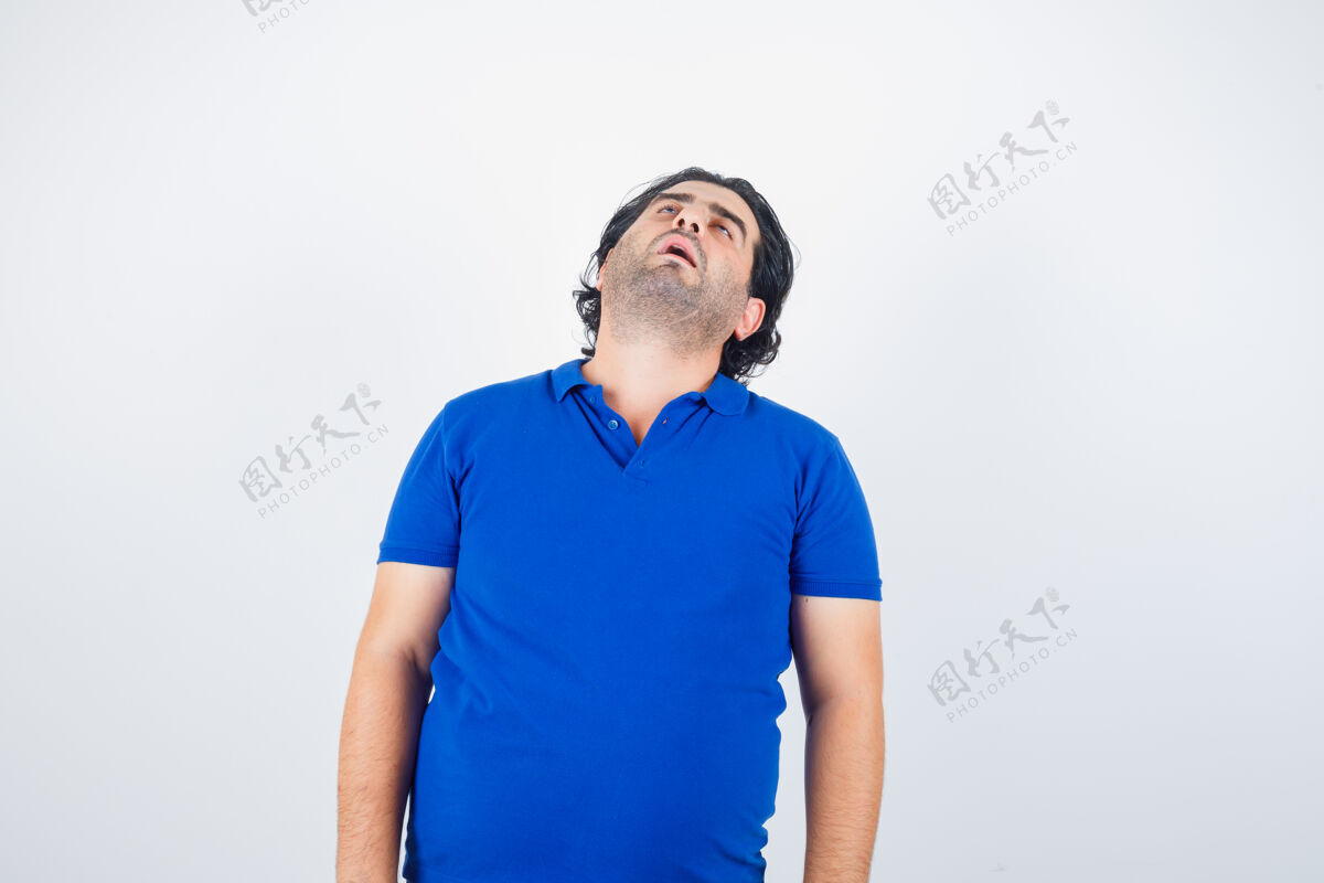 夜晚一个穿着蓝色t恤的成熟男人把头往后弯 看起来很困倦休闲睡衣睡觉