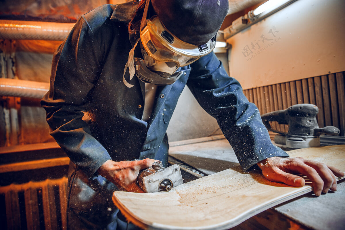 工作场所使用圆锯切割木板的木匠男工人或手持电动工具的手巧工人的施工详图桌子手木工