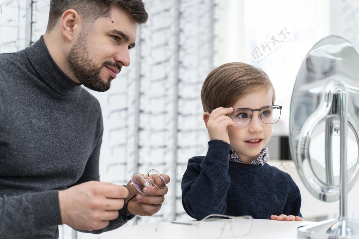 孩子小男孩和爸爸在店里试眼镜光学镜子男孩