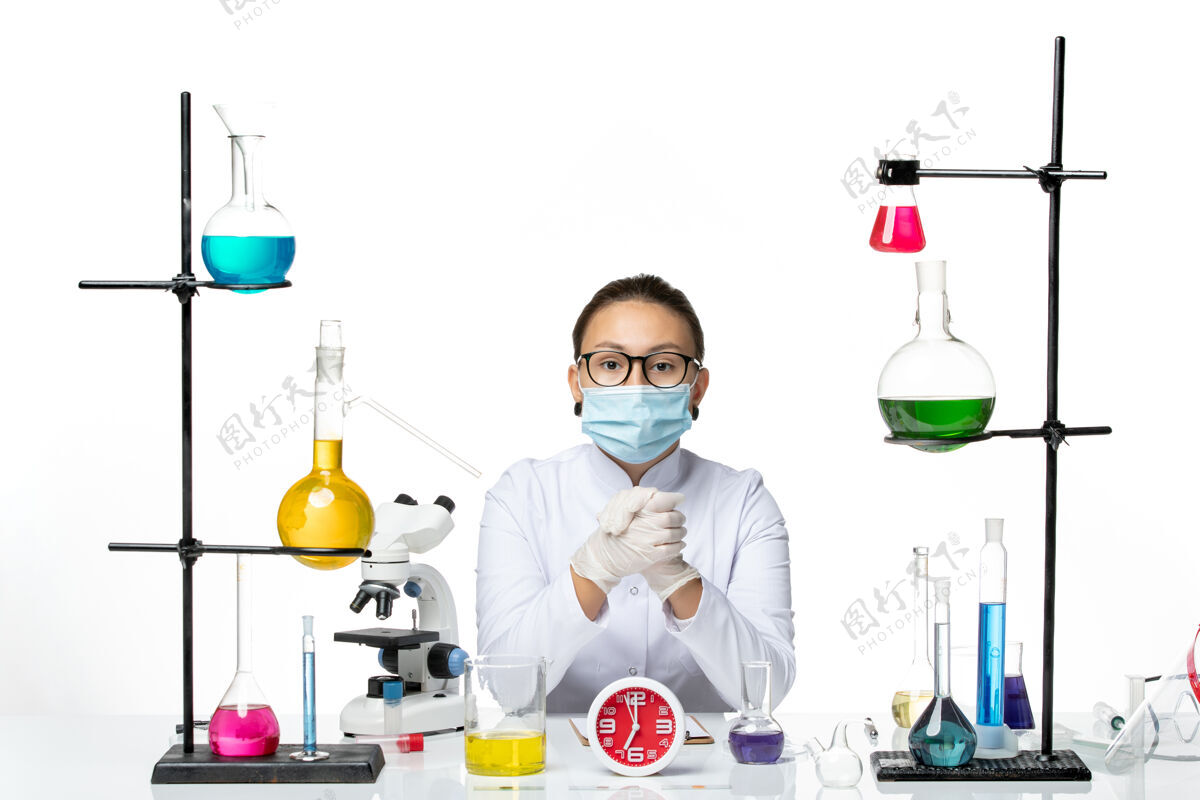 面具前视图穿着白色医疗服的女化学家带着面罩坐在白色背景上的解决方案化学家病毒-飞溅实验室医学实验室喷溅