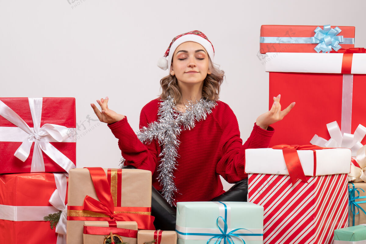 年轻女性正面图年轻女性围坐在圣诞礼物旁沉思购物美丽女人