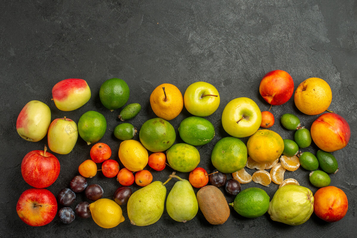 柑橘顶视图水果组成深灰色背景上的新鲜水果柠檬苹果葡萄
