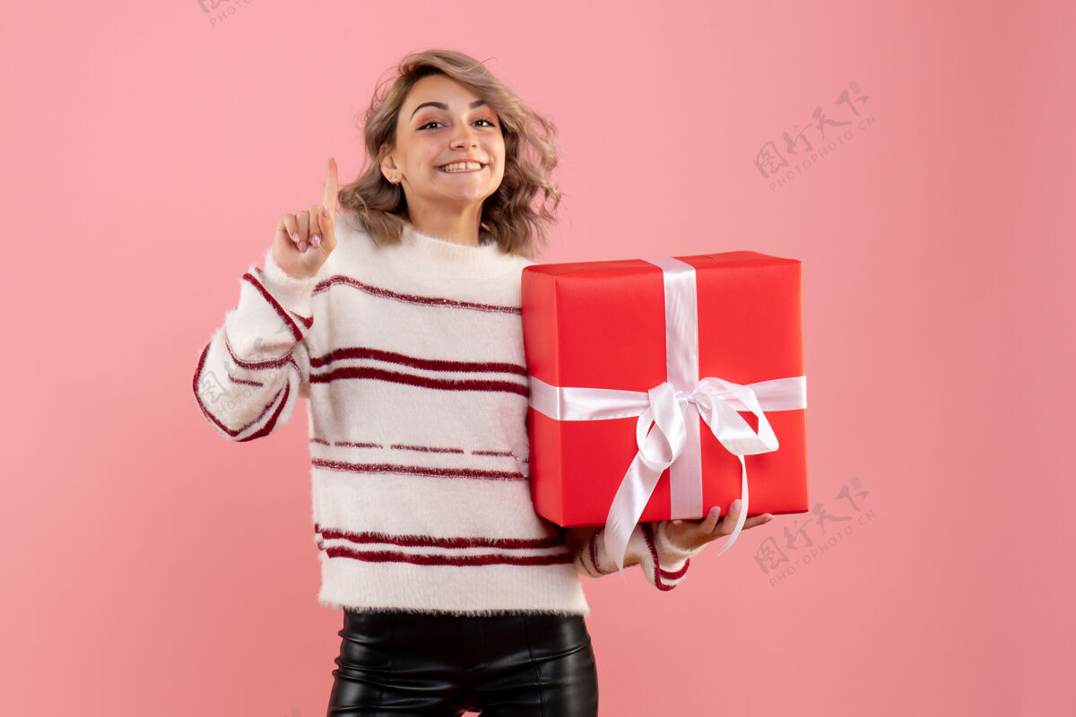 情感正面图年轻女性手持圣诞礼物年轻女性礼物成人