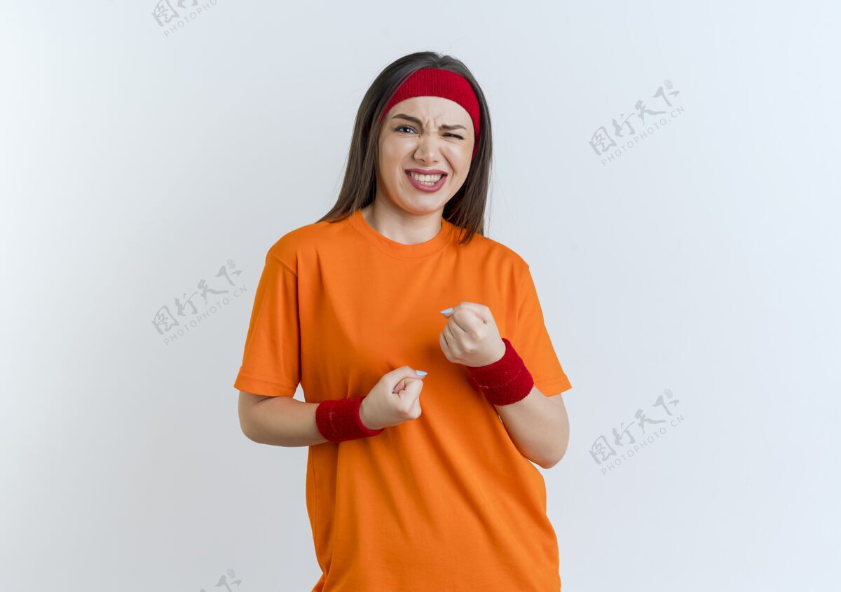 女人自信的年轻运动女性戴着头带和腕带握紧拳头看起来孤立运动年轻人头带
