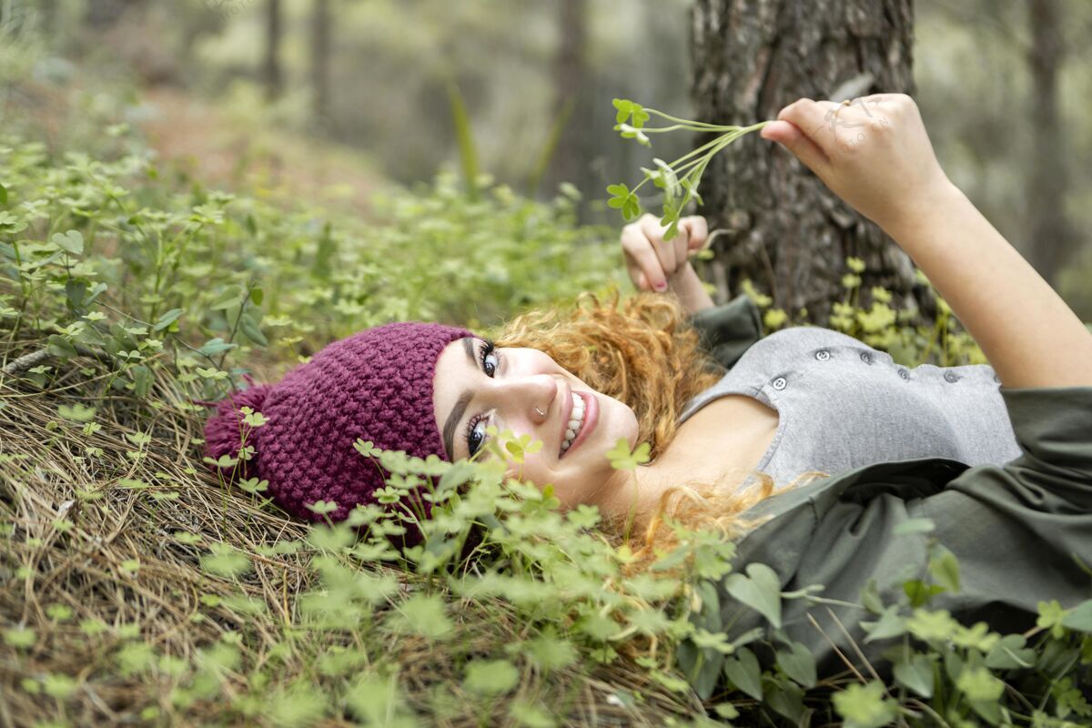 情感笑脸女人躺在草地上肖像美丽水平