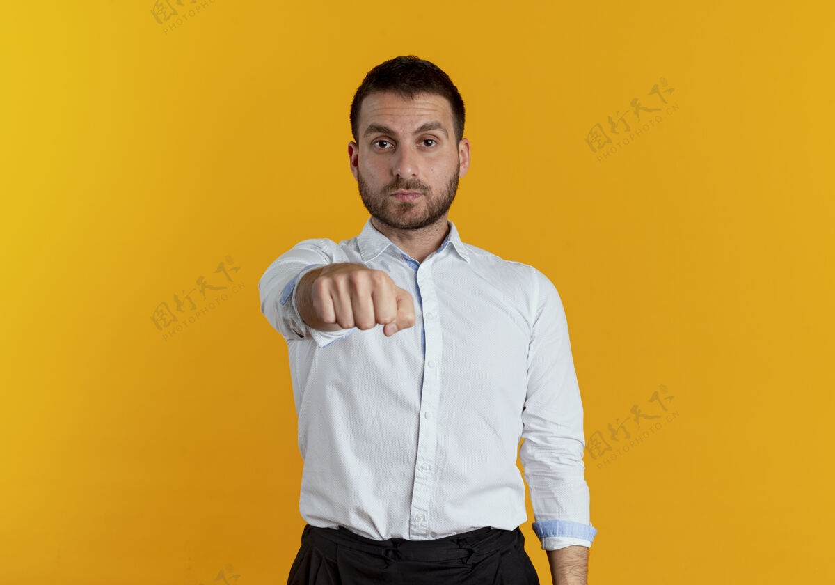 自信自信的帅哥在橙色的墙上伸出拳头持之以恒男人拳头