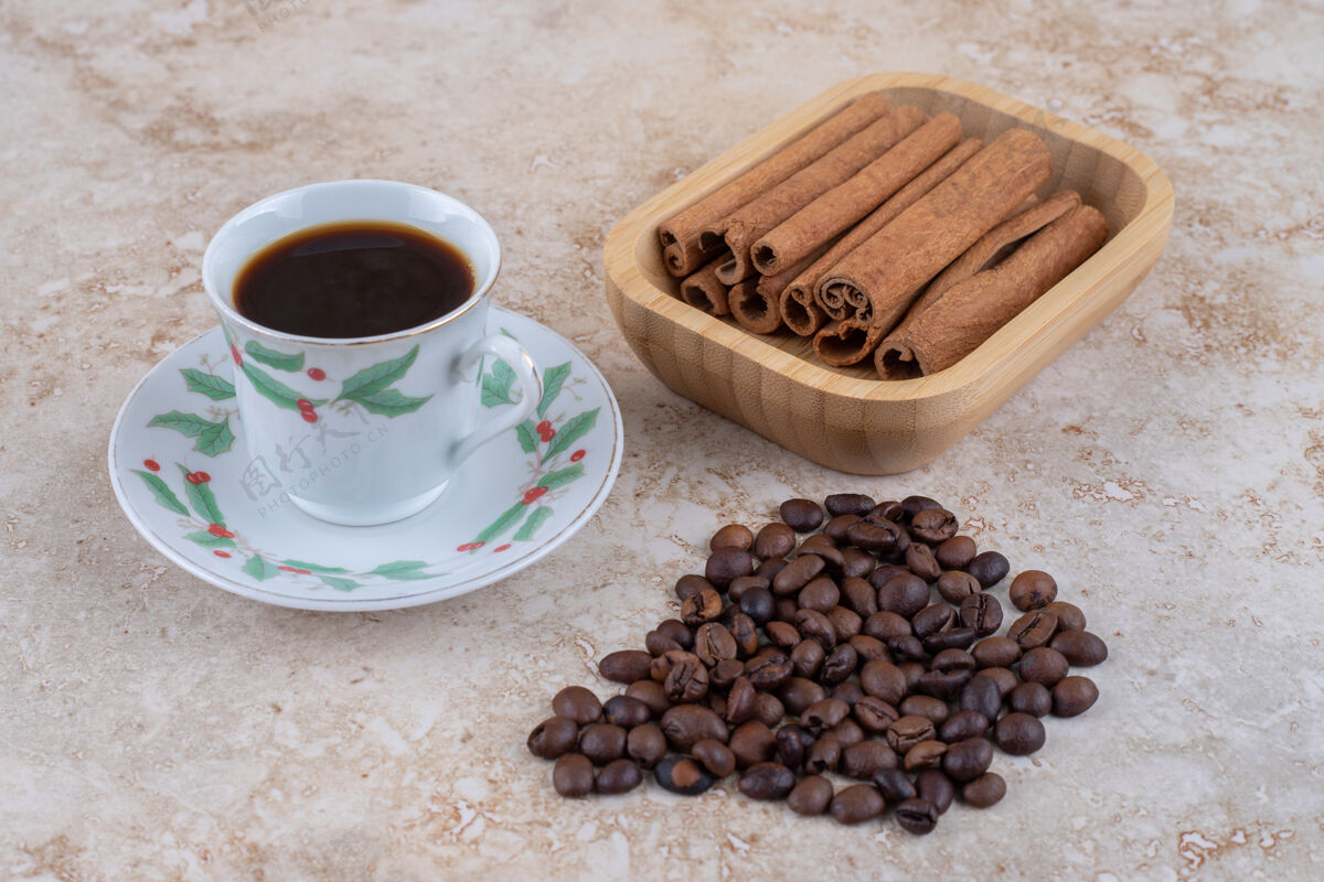 咖啡因一杯咖啡旁边是一捆捆的肉桂条和咖啡豆豆子咖啡芳香
