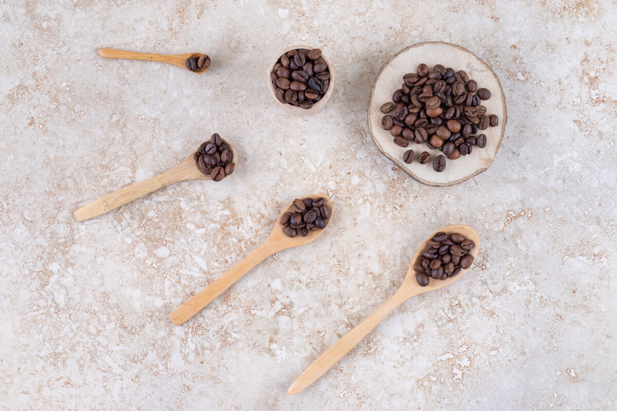 咖啡因香喷喷的咖啡豆装在勺子上 一块木头和一个小杯杯子咖啡豆咖啡