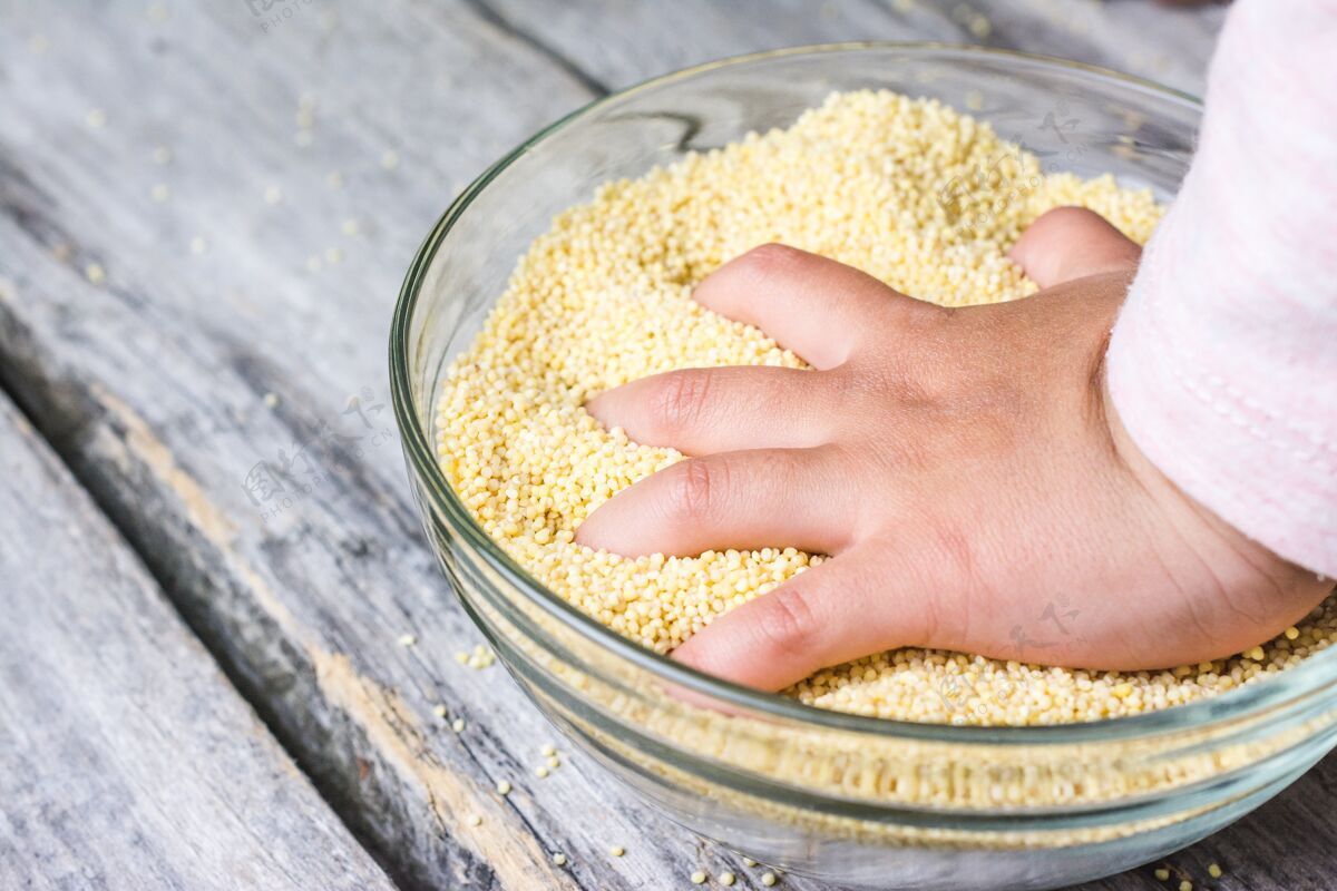 全麦一个婴儿的手放在一个新鲜的整个阿马拉特谷物碗特写镜头纤维小麦新鲜