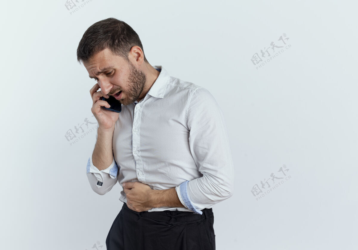 电话疼痛的帅哥抱着肚子 隔着白墙讲电话优雅年轻商人