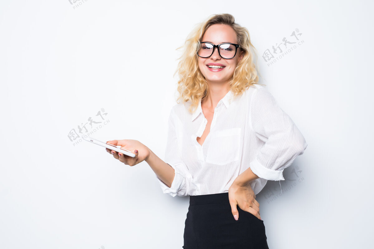 智能微笑的女商人在灰色的墙上用智能手机穿着蓝色衬衫和眼镜女人手机阅读