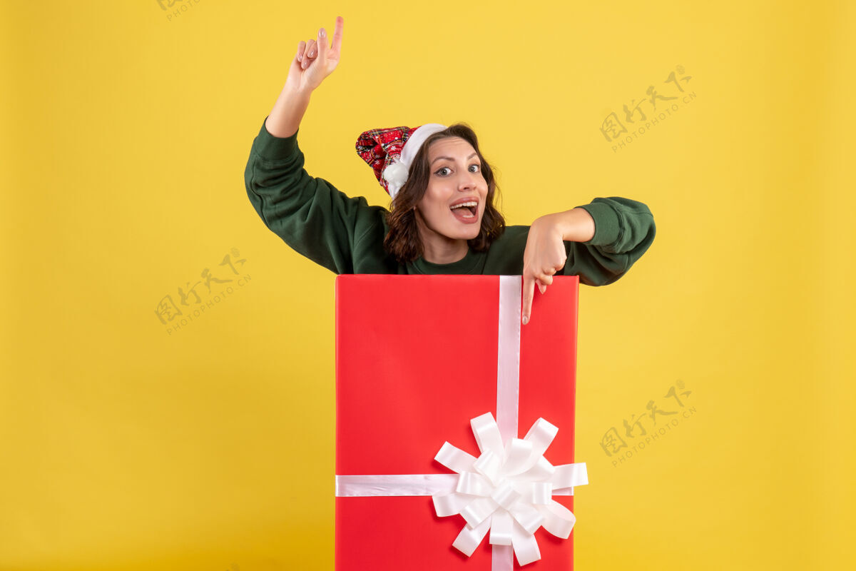 情感正面图年轻女性藏在黄色的礼物盒里高尔夫球手盒子圣诞节