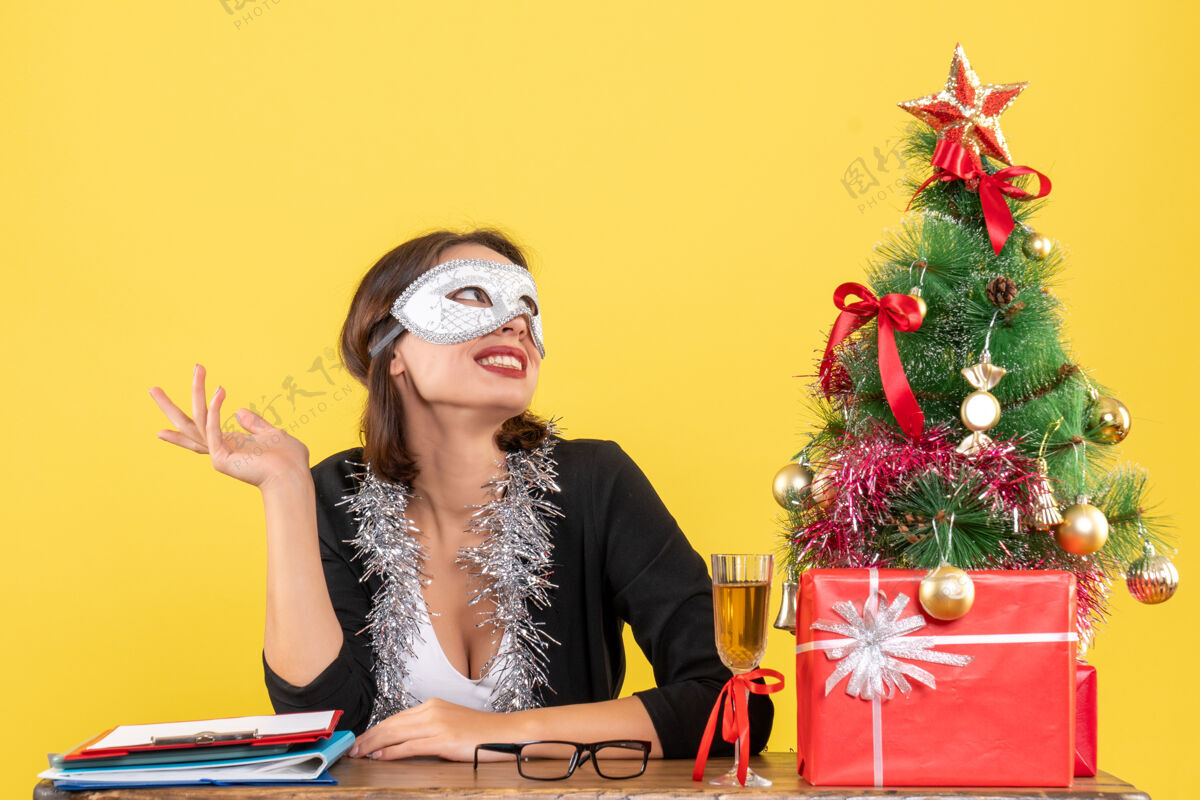 头发办公室里戴着面具的西装革履的梦幻迷人女士带来的新年气氛女士穿着套装