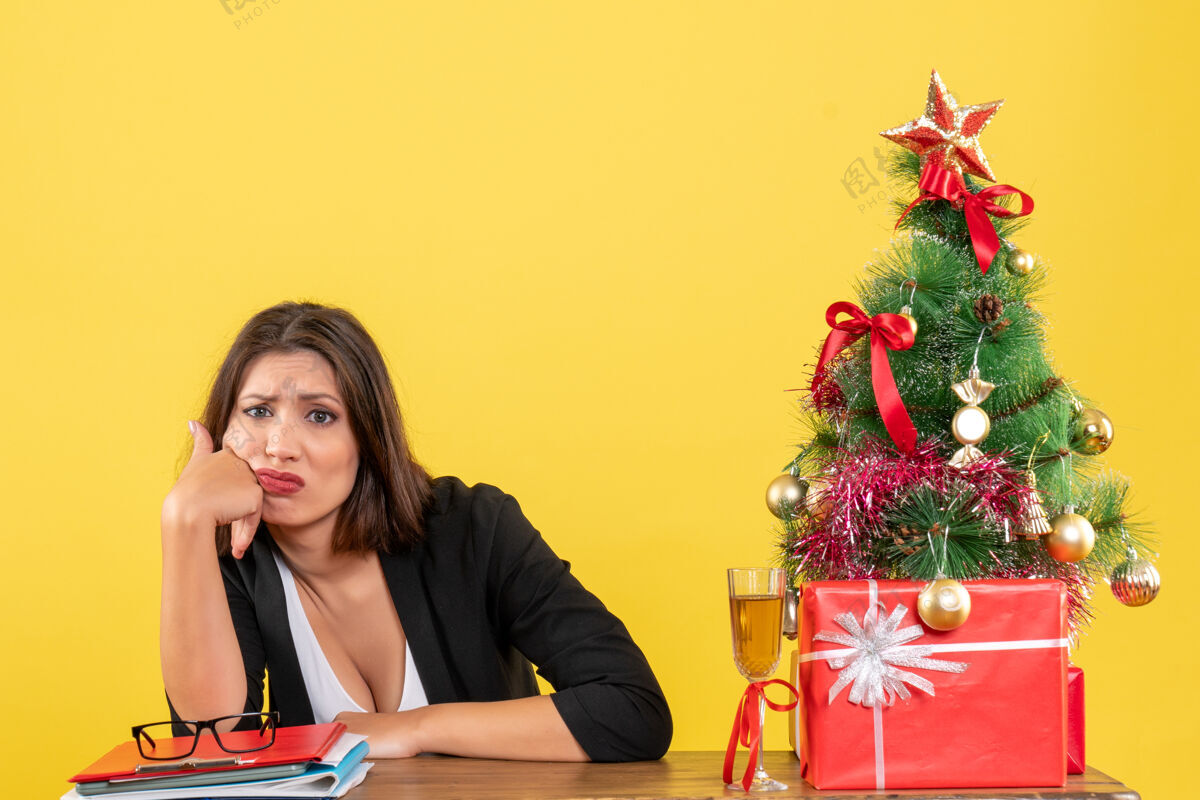 心情新的一年心情与美丽的不满意的业务女士困惑的东西 坐在一张桌子在办公室里人年人
