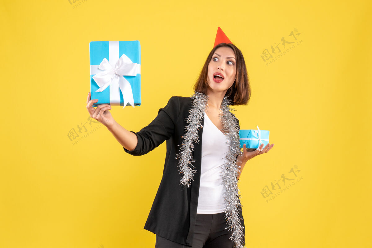 时尚圣诞节心情与情绪商务女士与xsmas帽子举行黄色礼物成人举行心情