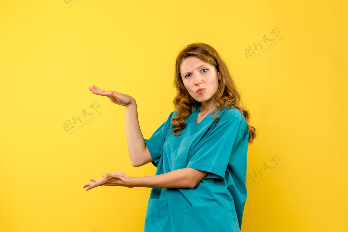 制服黄色墙上显示尺寸的女医生正面图黄色女人微笑