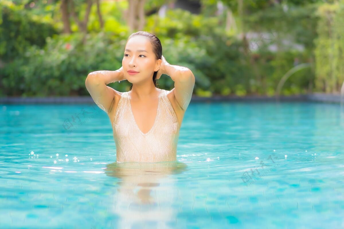 性感美丽的年轻女子在游泳池放松的画像阳光美丽阳光