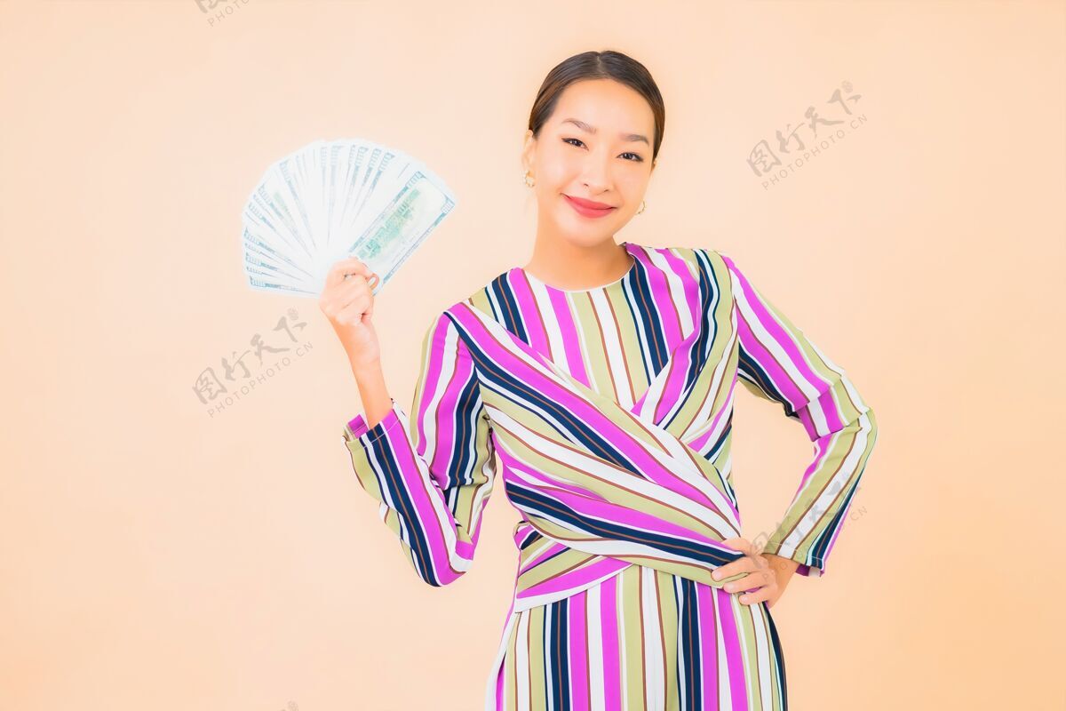 成人肖像美丽的亚洲年轻女子与现金或金钱和移动智能手机的颜色成功彩票美元