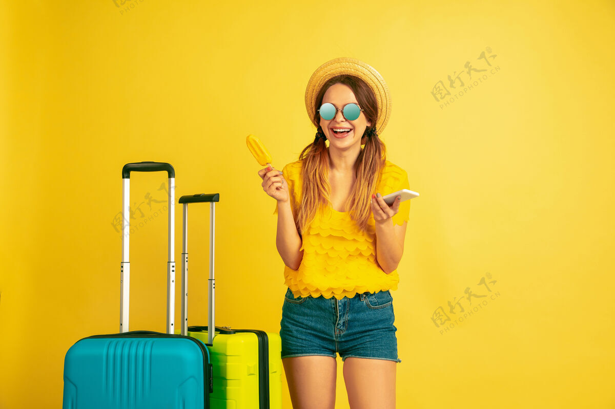 表情旅行前自拍黄色工作室背景上的白种女人肖像帽子里的美丽模特人类情感的概念 面部表情 销售 广告夏日 旅游 度假肖像成功面部