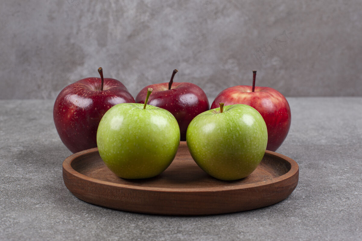 自然绿色和红色的苹果在木制的厨房板上多汁的农业美食