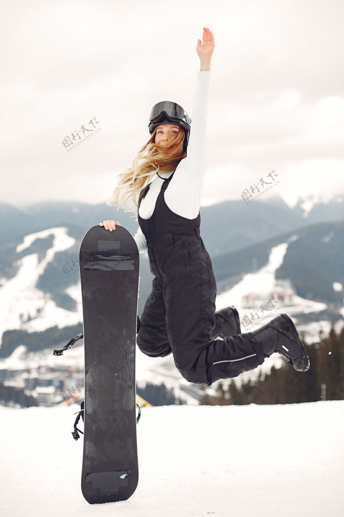 女人穿着滑雪板套装的女人在山上手拿滑雪板的运动员在地平线上关于运动的概念运动女孩设备