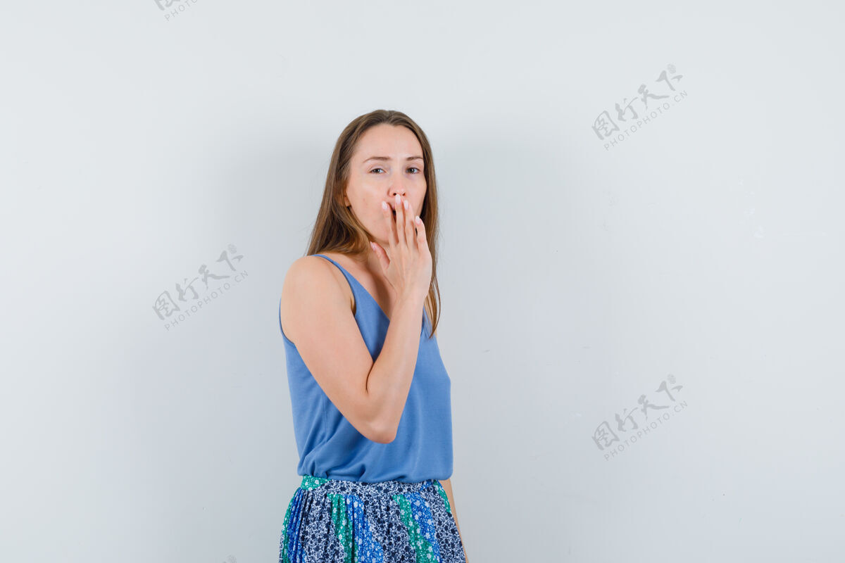Vip穿着蓝色上衣 裙子 手放在嘴上的年轻女士看起来很不舒服前视图文本空间诱惑不舒服魅力