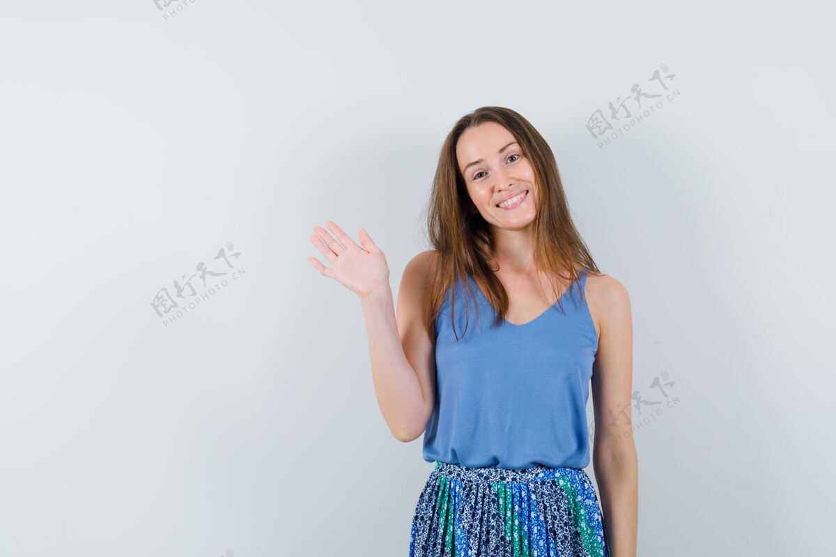 脸年轻的女士挥手告别在单身 裙子和期待愉快 前视图成人微笑水疗