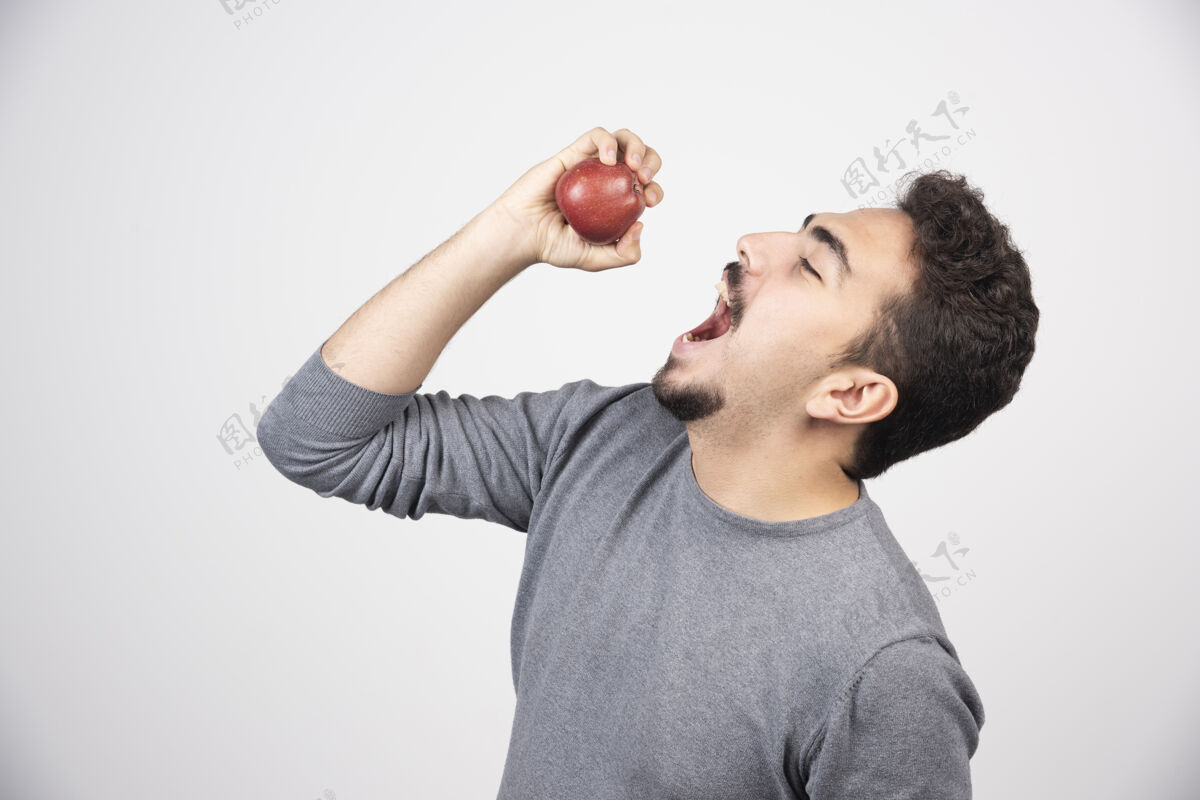 肖像黑发男人想吃红苹果人类人食物