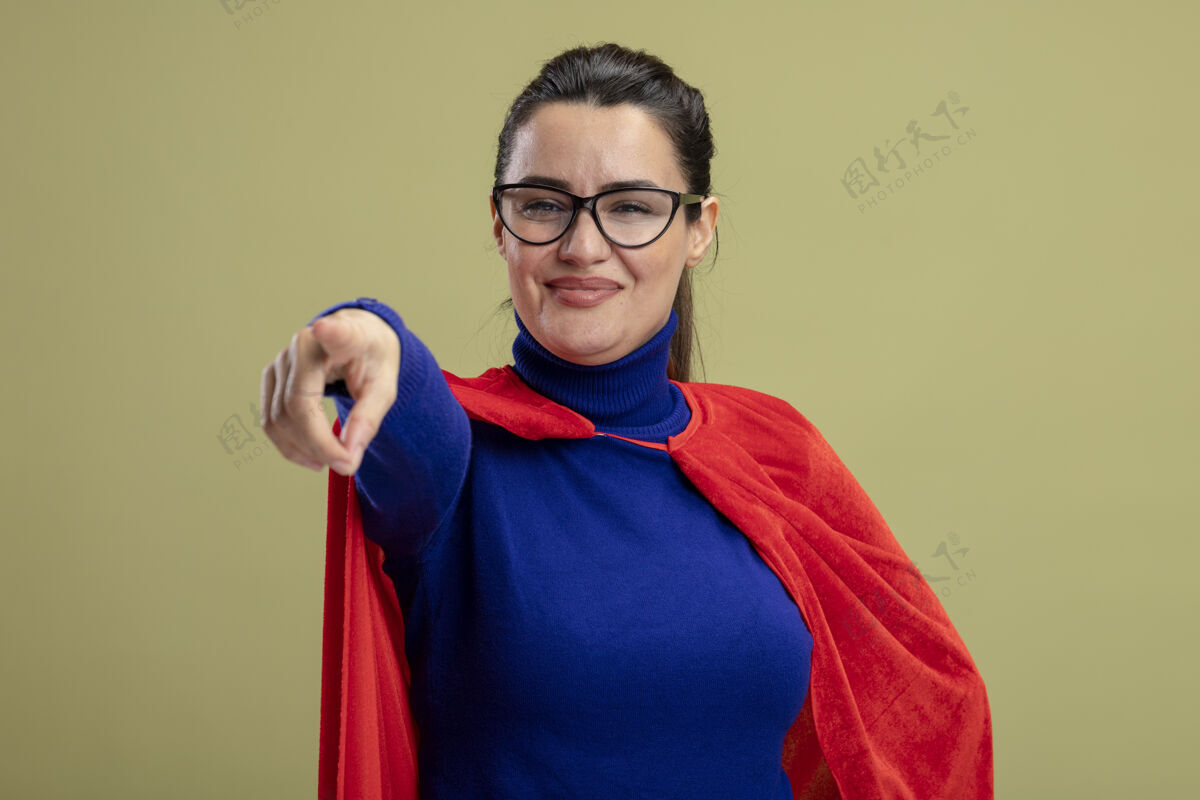 超级英雄高兴的年轻超人女孩戴着眼镜显示你的姿态孤立在橄榄绿的背景穿年轻手势