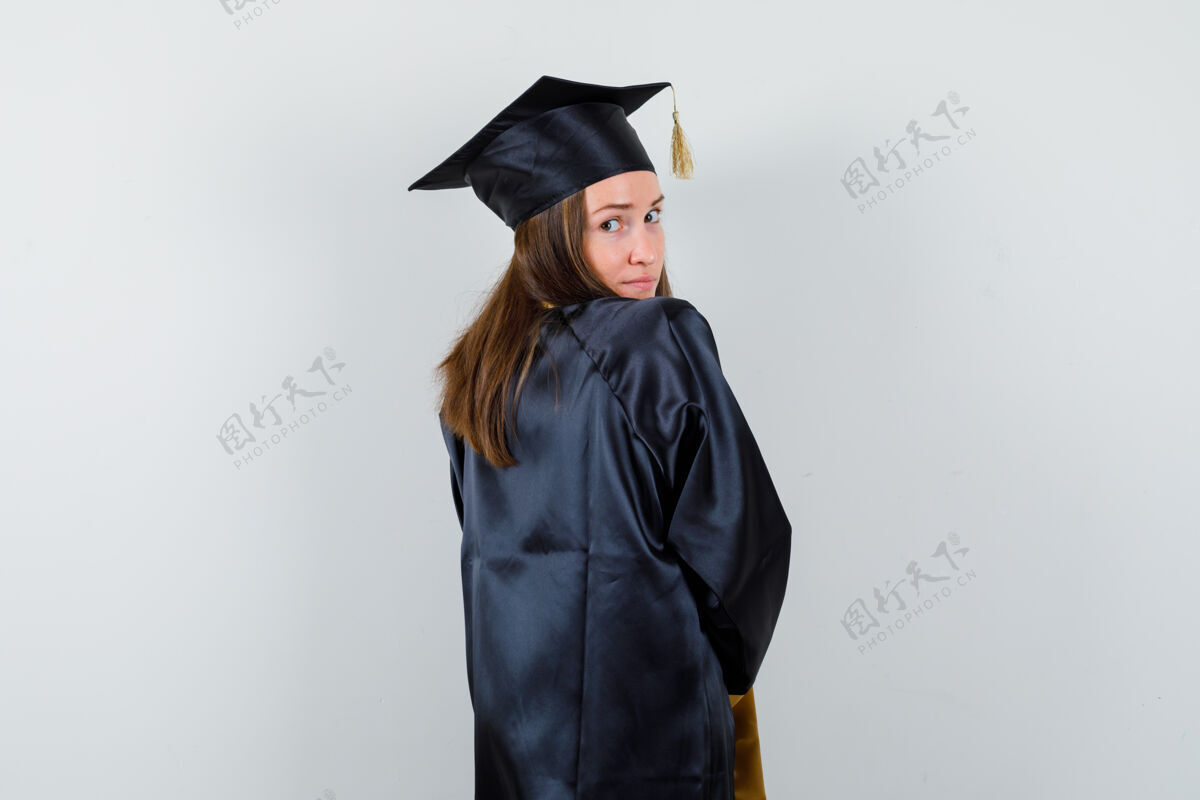 肩膀穿着学院服的女毕业生看着肩上的相机 看起来很可爱 背影欢呼单身多样性