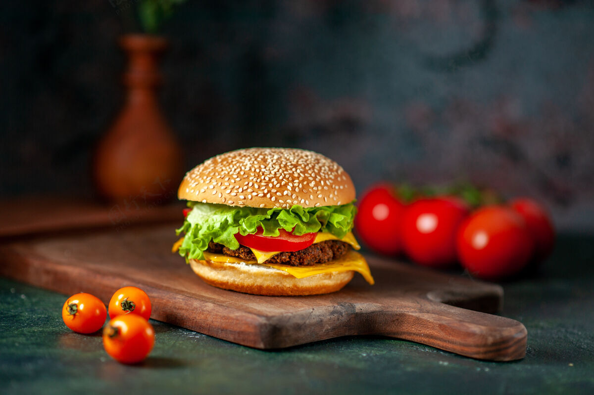 芝士汉堡前视图肉汉堡包与新鲜西红柿在黑暗的背景生菜奶酪美味